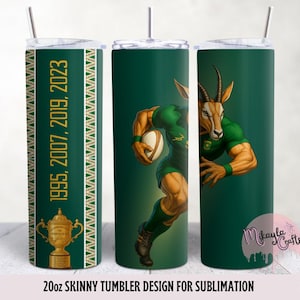 Puede incluir: Un vaso delgado de 20 oz con un fondo verde y un diseño que presenta un springbok musculoso sosteniendo un balón de rugby. El vaso también tiene los años 1995, 2007, 2019 y 2023, junto con un gráfico de trofeo. El vaso está diseñado para sublimación.