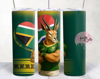 May include: A green 20oz skinny tumbler featuring a muscular springbok wearing a green and gold jersey, with the South African flag and the years 1995, 2007, 2019, and 2023. The tumbler has a silver lid and straw.