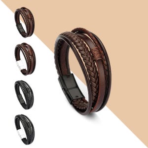 May include: A brown leather bracelet with a braided design and a black metal clasp. The bracelet is made of multiple layers of leather and has a woven texture.
