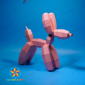 May include: A pink paper balloon dog sculpture with geometric shapes. The dog is standing on a blue surface. The sculpture is a creative craft project. The logo "YEN ART CRAFT" is visible.