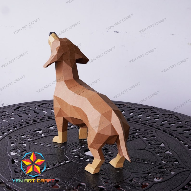 May include: A brown papercraft model of a dachshund dog standing on a black metal table. The dog is looking up and has its mouth open. The model is made of many small triangles and is very detailed.