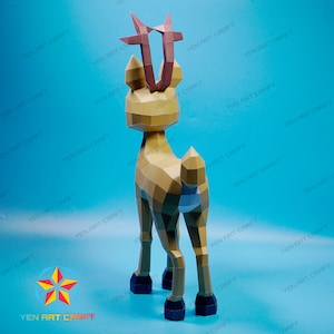 May include: A papercraft model of a deer with brown antlers and a light brown body. The deer is standing on a blue surface.