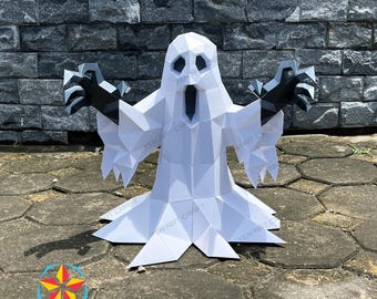 May include: A white, geometric paper ghost sculpture with black hands and facial features. The ghost has outstretched arms and a flowing bottom, perfect for Halloween or spooky decor. The sculpture is displayed outdoors.