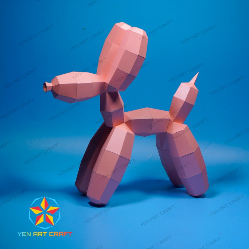May include: A pink papercraft balloon dog sculpture, with geometric shapes and a playful design. The sculpture is set against a blue background, with the text "YEN ART CRAFT" repeated around the edges.