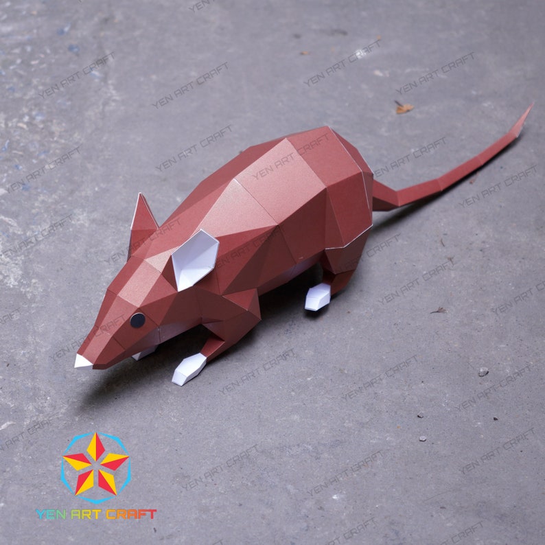 May include: A brown papercraft mouse model with white ears and feet. The model is posed on a gray surface.