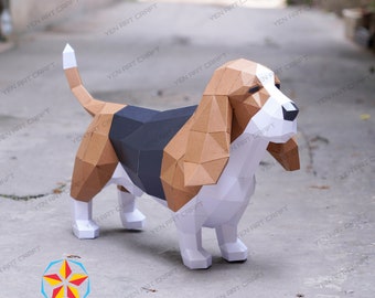 May include: A papercraft model of a brown and white basset hound dog. The dog is standing on a gray concrete surface.