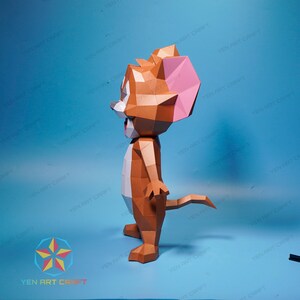 May include: A papercraft model of Tom from the cartoon Tom and Jerry. The model is made of brown, white, and pink paper and is posed standing with its tail curled behind it. The model is a 3D representation of the cartoon character.