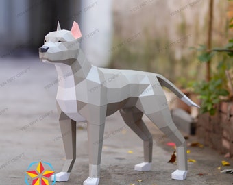 May include: A gray papercraft model of a dog standing on a gray concrete surface. The dog is made of folded paper and has a white chest and tail tip.
