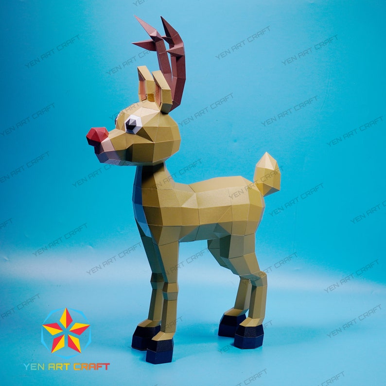 May include: A papercraft reindeer model with a red nose and antlers. The reindeer is standing on a blue background.