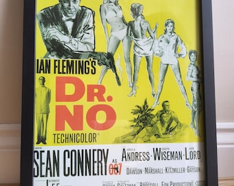 Op de afbeelding: Een vintage filmposter voor de eerste James Bond-film, "Dr. No", met Sean Connery als James Bond 007. De poster heeft een gele achtergrond met een zwarte en rode titel en een zwart-witte afbeelding van Sean Connery in smoking.