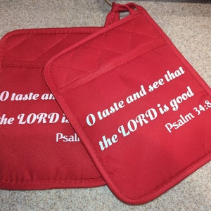 May include: Two red quilted pot holders with white text. The text on the pot holders reads "O taste and see that the LORD is good Psalm 34:8".