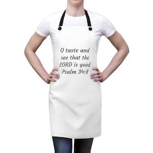 May include: White apron with black straps and the text "O taste and see that the LORD is good Psalm 34:8" printed on the front.