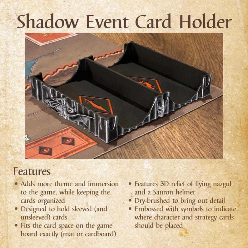 Może przedstawiać: Czarny uchwyt na karty Shadow Event z trzema przegr&oacute;dkami, z wytłoczonymi symbolami i tr&oacute;jwymiarowym reliefem latającego Nazg&ucirc;la i hełmu Saurona. Zaprojektowany do organizowania kart w koszulkach i bez koszulek do gier planszowych.