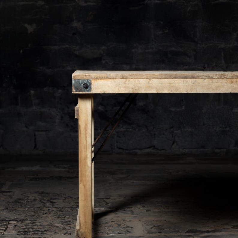 May include: A rustic wooden table with a natural wood finish and metal accents. The table is made of reclaimed wood and has a distressed look. The table is perfect for a farmhouse or industrial style home.