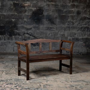May include: A wooden bench with a curved back and armrests. The bench is made of dark brown wood and has a simple design.