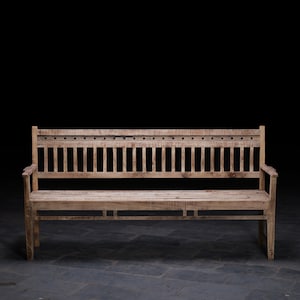 May include: A long wooden bench with a slatted back and a simple design. The bench is made of light-coloured wood and has a natural finish.