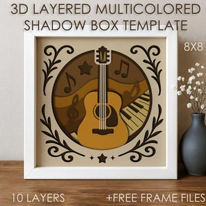 Könnte beinhalten: Eine mehrschichtige 3D-Schattenbox-Vorlage mit einem musikalischen Thema. Das Design zeigt eine Gitarre, Noten und eine Klaviatur in einem kreisförmigen Rahmen. Das Kunstwerk befindet sich in einem weißen Rahmen mit dem Text "3D LAYERED MULTICOLORED SHADOW BOX TEMPLATE" und "8x8 SIZE".