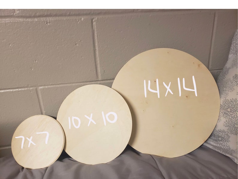May include: Three round wooden discs of different sizes. The largest disc is 14 inches by 14 inches, the middle disc is 10 inches by 10 inches, and the smallest disc is 7 inches by 7 inches. The discs are all made of light-colored wood and have white writing on them.