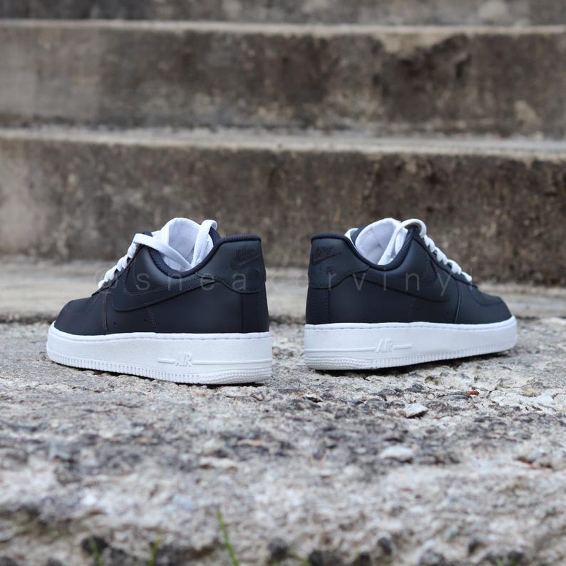 May include: A pair of black leather low-top sneakers with white soles and laces. The sneakers have a Nike logo on the side.