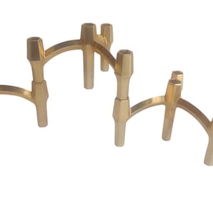 Peut inclure: Un chandelier en métal doré avec huit bougeoirs. Le chandelier est composé d'une série d'arches reliées.