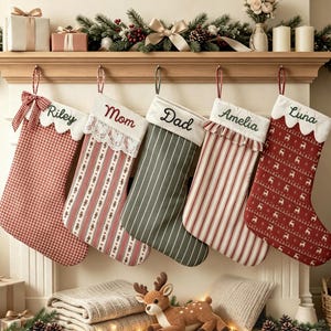 Può includere: Cinque calze natalizie appese con i nomi personalizzati Riley, Mom, Dad, Amelia e Luna. Le calze presentano vari motivi, tra cui quadretti vichy rossi, righe e stampe di renne, con dettagli decorativi in pizzo e bordi arricciati.
