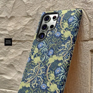 Pu&ograve; includere: Una custodia per telefono blu con un motivo floreale in tonalit&agrave; di verde, giallo e blu. La custodia ha un ritaglio per l'obiettivo della fotocamera.