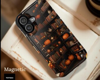 May include: A black smartphone case featuring a printed design of dark wooden bookshelves filled with rows of books, small white teapots, and orange pumpkins. The case has a dual-camera cutout and the text Magnetic and TOTESI DESIGN printed nearby.