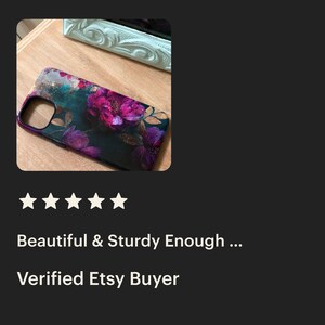 May include: A black phone case with a floral design featuring pink and purple flowers and gold accents.
