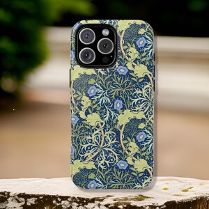 Pu&ograve; includere: Una custodia per telefono con un motivo floreale in tonalit&agrave; di blu, verde e giallo. La custodia ha un ritaglio per l'obiettivo della fotocamera.