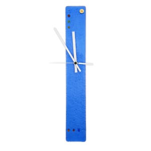 May include: A contemporary, rectangular wall clock in a striking blue. It has white hands and colourful dot accents. The clock measures approximately 7.6 cm wide and 30.5 cm long.