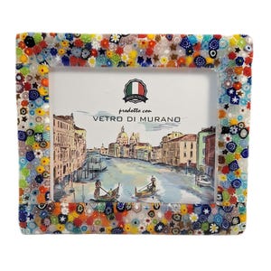 May include: Rectangular photo frame with a colorful mosaic border. The frame features a detailed illustration of a Venetian canal scene. The text "prodotto con VETRO DI MURANO" and "MADE IN ITALY" are visible.