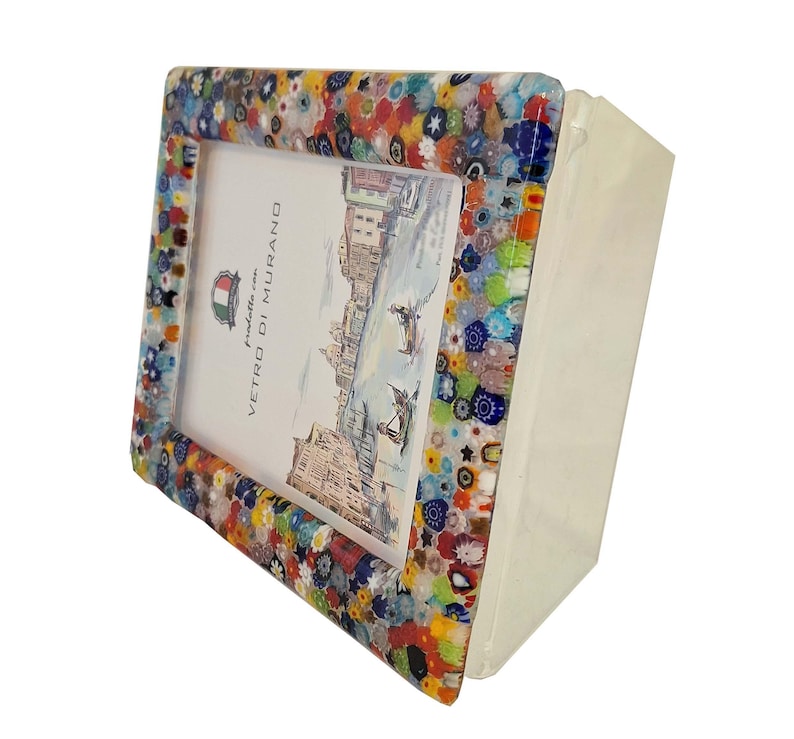 May include: A colorful, rectangular picture frame with a mosaic-like border. The frame features a variety of colors, including blue, red, yellow, and green. The frame holds a picture with a detailed illustration and the text "Vetro di Murano".