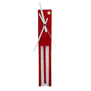 May include: A rectangular red wall clock with white clock hands. The clock has a vertical design with a white and red striped pattern at the bottom. A small gold-colored circular emblem is at the top.