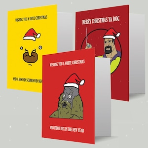 Peut inclure: Trois cartes de Noël avec des illustrations humoristiques. Une carte est jaune avec un visage de dessin animé et du texte. Une autre est rouge avec un homme portant un chapeau de Père Noël. La troisième est rouge avec une créature portant un chapeau de Père Noël.