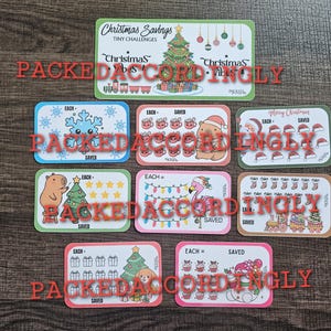 May include: A collection of eight rectangular Christmas savings challenge cards featuring colorful illustrations of a decorated tree, a snowflake, a capybara, a flamingo, a snowman, and holiday icons with text including Christmas Savings and Tiny Challenges.