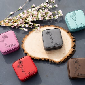 May include: Six small square jewellery boxes with floral designs and personalised names. The boxes are in various colours, including pink, grey, blue, black, red and brown.
