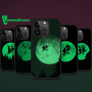 May include: Black phone cases with a glowing green moon and silhouette of a person riding a bicycle. The cases feature a forest scene and a person on a bicycle in front of the moon. The cases have the logo "ImpressStudio" in green.