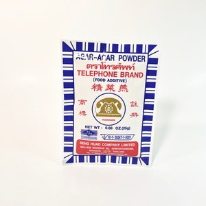May include: A blue and white package of Agar-Agar powder, labeled "Telephone Brand" in Thai and English. The package also includes the text "Food Additive" and "精菜燕" in Chinese characters. The net weight is 0.88 ounces (25 grams).