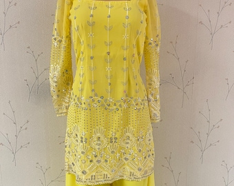May include: A yellow embroidered top with silver sequins and a matching pair of yellow palazzo pants.
