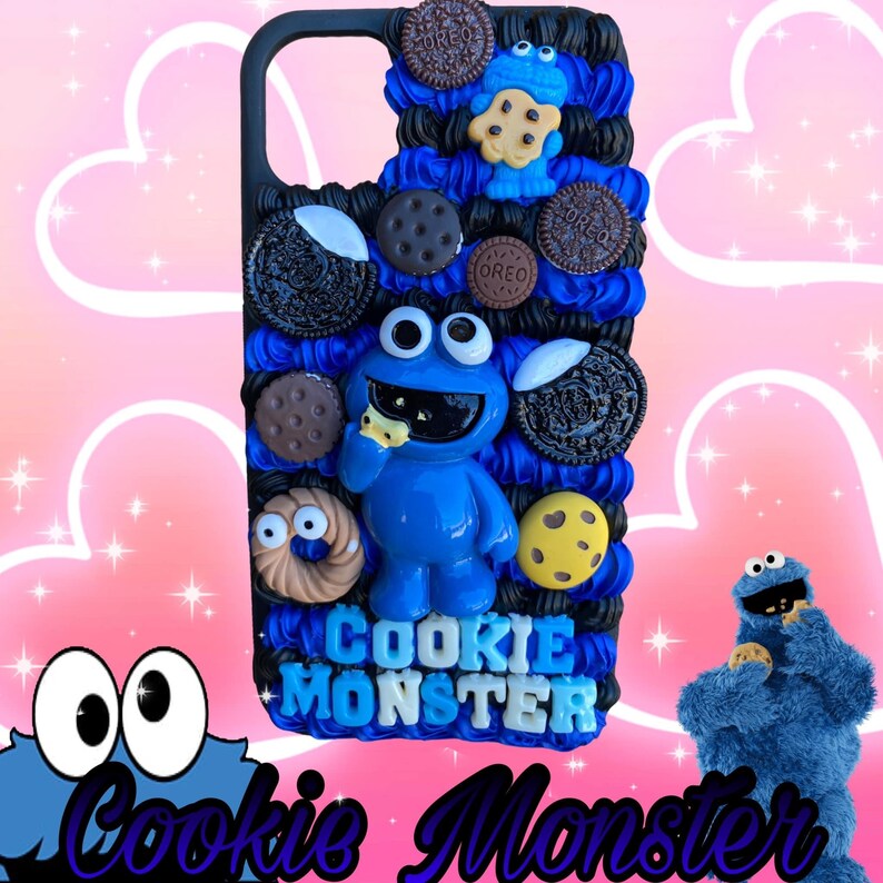 May include: A black phone case decorated with a blue Cookie Monster figure eating a cookie, surrounded by various cookies. The words "Cookie Monster" are displayed in blue and white. The background is pink with hearts.