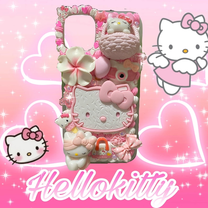 May include: A pink and white Hello Kitty phone case with 3D embellishments. The case features a large Hello Kitty face, bows, flowers, and a small Hello Kitty figure in a basket. The word "Hellokitty" is written in pink script at the bottom.