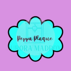 May include: A turquoise blue cloud-shaped cookie cutter with a black outline. The cutter features the text "Peppa Plaque" and "UPORA MADDOX" in black lettering.