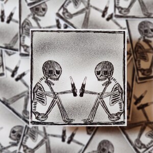 Dos esqueletos sentados animando sus botellas, calcomanía de vinilo brillante, calcomanía para computadora portátil, decoración de diario, calcomanía de humor negro ingenioso, calcomanía de calavera