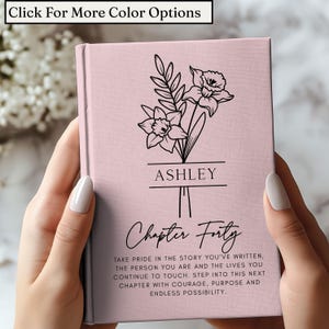 Peut inclure: Un journal rose avec un motif floral et le nom "ASHLEY" en noir. Le texte "Chapter Forty" est en dessous du nom, avec un texte inspirant en dessous. Le haut du journal indique "Click For More Color Options".