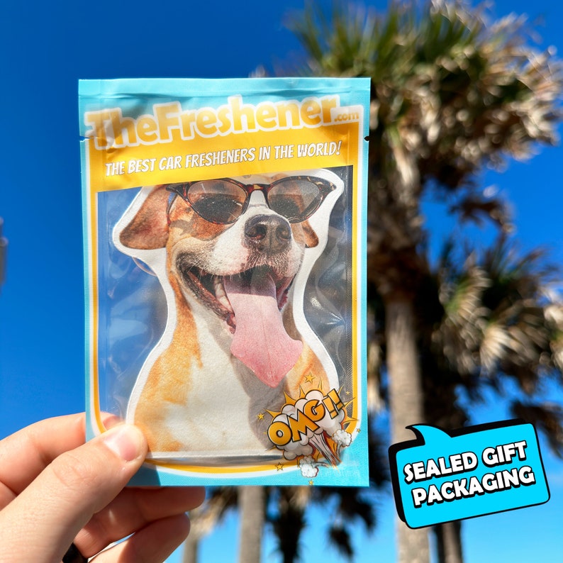 Pu&ograve; includere: Un pacchetto sigillato di un deodorante per auto con un cane che indossa occhiali da sole. La confezione &egrave; blu e gialla con il testo "TheFresher.com" e "The best car fresheners in the world!" La confezione contiene anche il testo "OMG!" e "Sealed Gift Packaging".