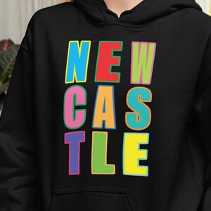May include: Black hooded sweatshirt with a colourful "NEWCASTLE" graphic printed on the front.