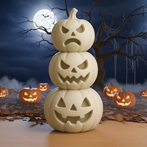 Può includere: Una pila di tre zucche di Halloween bianche con facce intagliate, ambientata in una scena notturna con luna piena e albero spoglio. Le lanterne Jack-o'-lanterns illuminate sono sparse sullo sfondo, creando un'atmosfera spettrale.