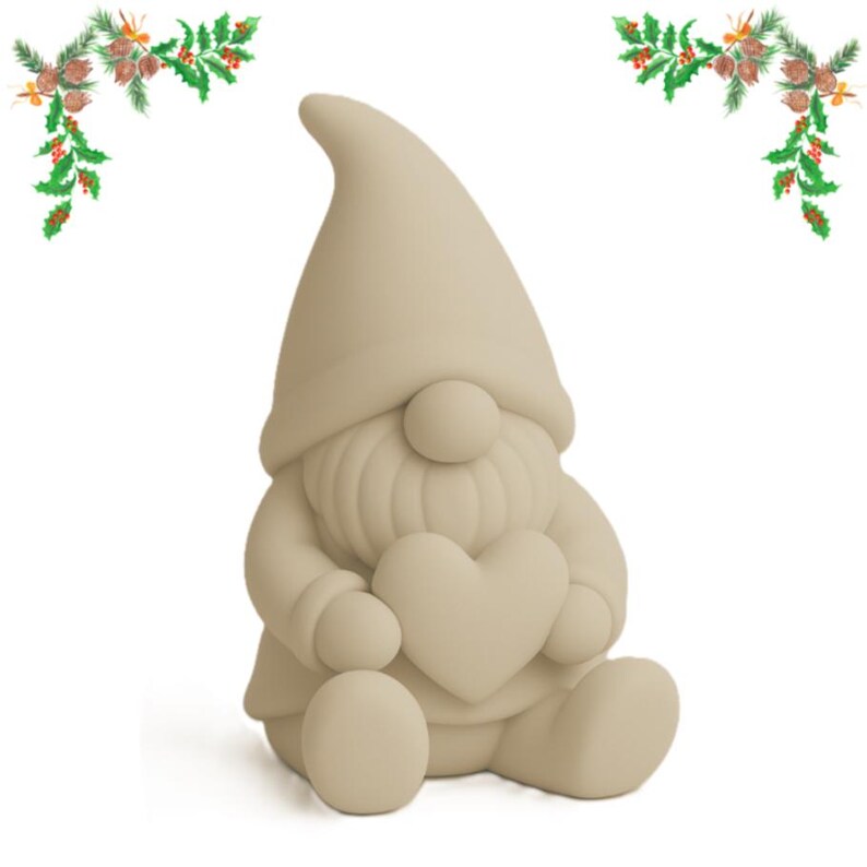 May include: A beige gnome figurine holding a heart. The gnome has a pointed hat, a round nose, and a long beard. The figurine is sitting down and has a round body. Decorative greenery with berries and pinecones is in the corners.