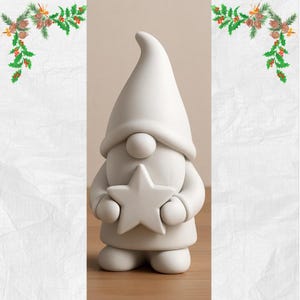 Puede incluir: Figura de gnomo de cerámica blanca sosteniendo una estrella. El gnomo tiene un sombrero grande y puntiagudo, una nariz redonda y un cuerpo redondeado. La figura está diseñada para ser pintada o decorada. El fondo es de color neutro.