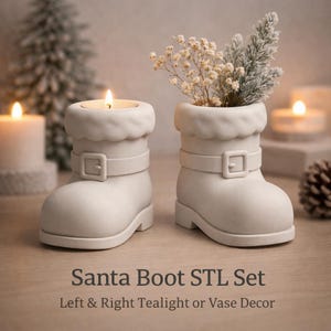 Op de afbeelding: Twee witte kerstmanlaarsvormige decoraties. Eén bevat een brandende kaars, de andere kleine witte bloemen en groen. Elke laars heeft een riem met een vierkante gesp. De tekst "Santa Boot STL Set" en "Left & Right Tealight or Vase Decor" staat onderaan.